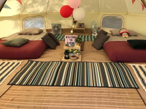 2 Betten in einem Zelt mit Ballons und einem Teppich in der Unterkunft Glamping kaki singapore-Standard medium bell tent in Singapur