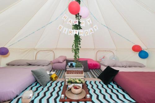 a room with two beds in a tent with balloons at Glamping kaki singapore-Standard medium bell tent in Singapore