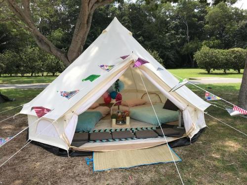 ein weißes Zelt mit einem Bett auf einem Feld in der Unterkunft Glamping kaki singapore-Standard medium bell tent in Singapur