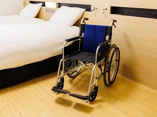 wózkiem inwalidzkim w pokoju obok łóżka w obiekcie Hotel Dream Gate Maihama Annex w Tokio