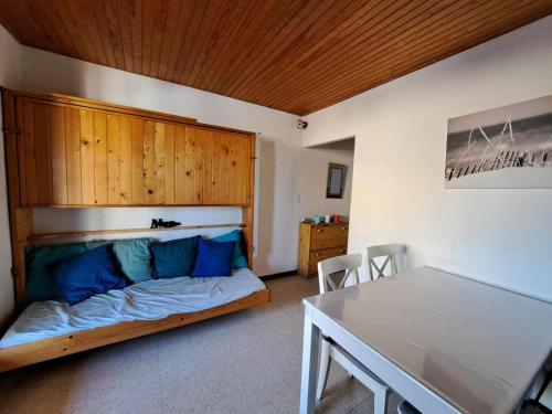 Zimmer mit einem Bett mit blauen Kissen und einem Tisch in der Unterkunft Appartement Marseillan-Plage, 3 pièces, 6 personnes - FR-1-326-642 in Marseillan