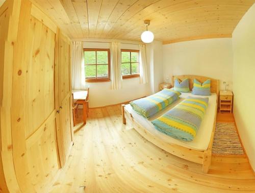 1 dormitorio con 1 cama grande en una habitación de madera en Ferienwohnung mit Terrasse und Spielplatz für Kinder, en Longega