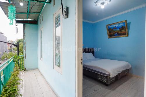 a bedroom with a bed in a blue wall at Fajar Inn Mitra RedDoorz in Jakarta