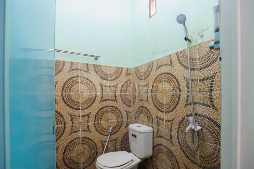 a bathroom with a toilet and a shower at Fajar Inn Mitra RedDoorz in Jakarta