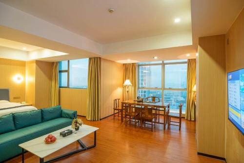 ein Wohnzimmer mit einem Sofa und einem Esszimmer in der Unterkunft Green Island Holiday Hotel in Jiangmen