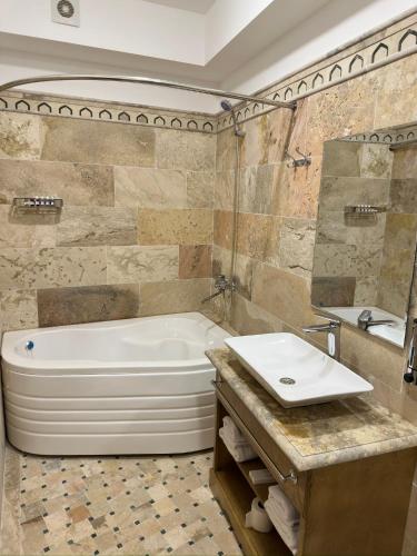 a bathroom with a white tub and a sink at Istat Boutique Hotel in Bukhara