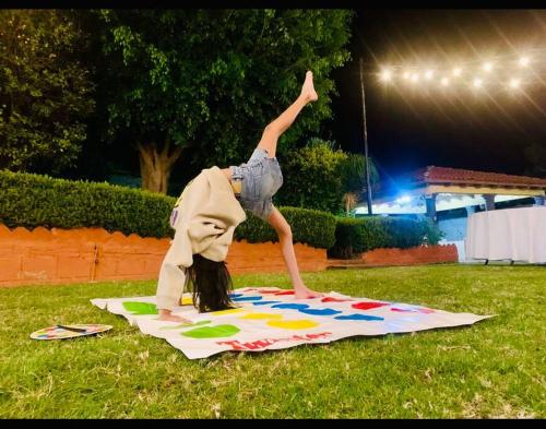 Ein junges Mädchen, das einen Handstand auf einer Decke macht. in der Unterkunft Casa estilo Campirano Jardín de los Soles in Taxco de Alarcón