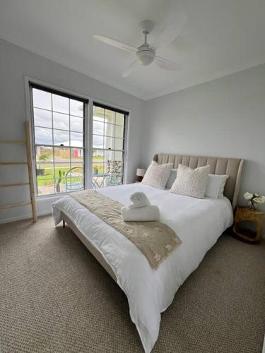a bedroom with a large bed with a large window at Wait and Sea Bargara in Bargara