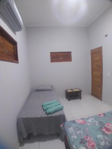 ein Schlafzimmer mit 2 Betten und einem Tisch darin in der Unterkunft Yanne chalé 1 in Barra Grande