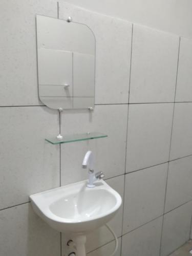 a white bathroom with a sink and a mirror at Yanne chalé 1 in Barra Grande