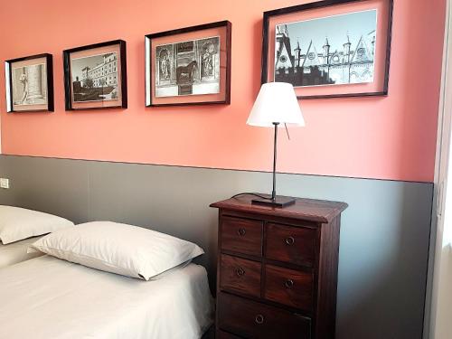 a bedroom with two beds and a lamp on a dresser at Foresteria Juvarra in Mantova