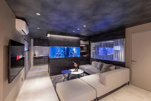 a living room with a couch and a fish tank at JAPAVISTA Aqua in Osaka