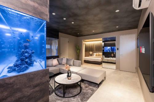 a living room with an aquarium and a couch at JAPAVISTA Aqua in Osaka