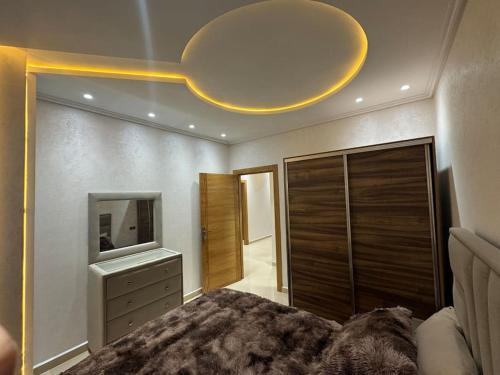 a bedroom with a large bed and a mirror at Family-sized Cosy Apartment in Larache