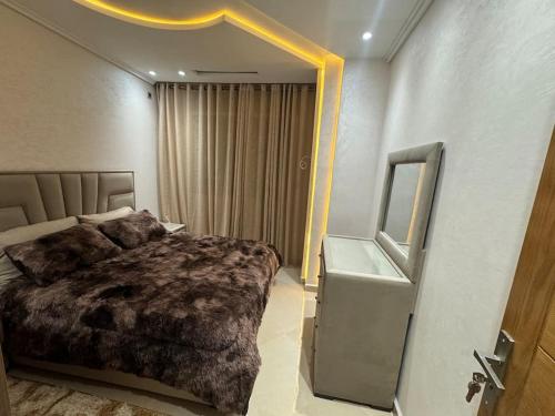 a bedroom with a large bed and a mirror at Family-sized Cosy Apartment in Larache
