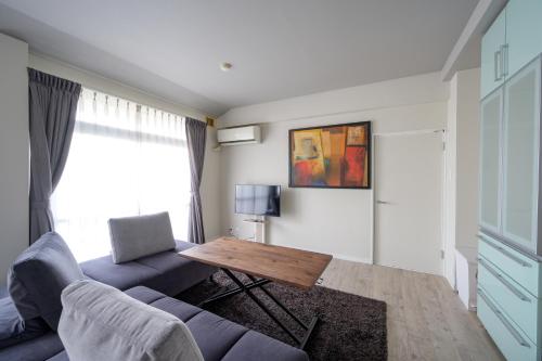 a living room with a blue couch and a table at WoodHigh ROOMS in Wakayama