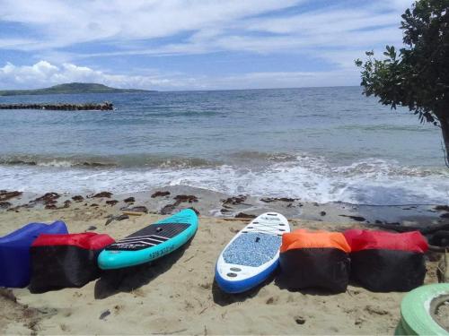 a group of surfboards sitting on the beach at Destiny Rainbow Beach Resort in Siquijor