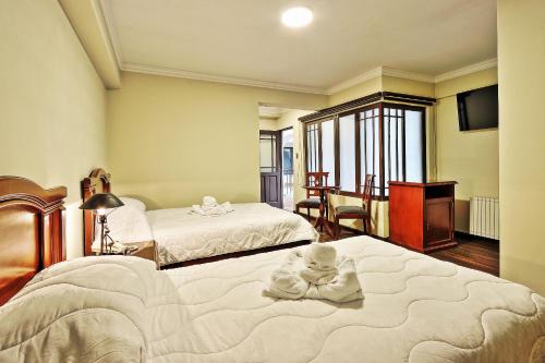 1 dormitorio con 2 camas y toallas. en Hostal Patrimonio - Potosi en Potosí