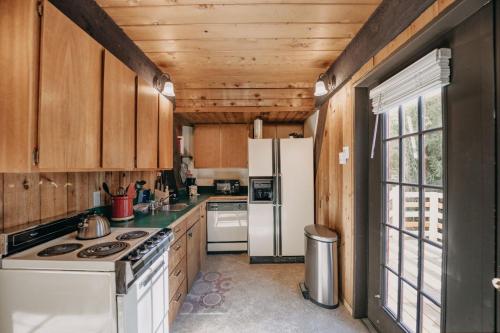 a kitchen with wooden cabinets and a white refrigerator at 05MBH - Economical - WiFi - Pets Ok - F P - D W - Sleeps 2 apts in Maple Falls