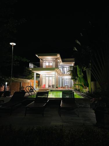 a house at night with a pool in front of it at Khalid’s House at the East coast in Phu Quoc