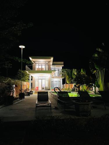 a house at night with a chair in front of it at Khalid’s House at the East coast in Phu Quoc