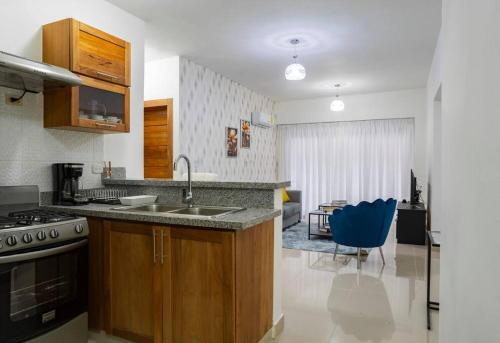 cocina con fregadero y silla azul en Torre Sky 01 - Apto. J9, en Santo Domingo