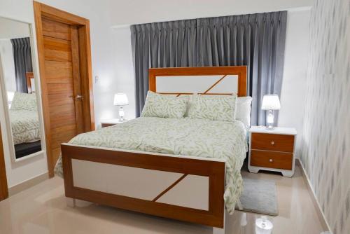 Un dormitorio con una cama grande y dos mesitas de noche. en Torre Sky 01 - Apto. J9, en Santo Domingo