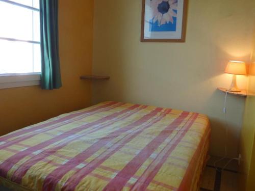 - une chambre avec un lit doté d'une couette à rayures et d'une fenêtre dans l'établissement Maison de vacances à 100m de la plage, 4 pers, jardin, stationnement - Notre-Dame-de-Monts - FR-1-540-257, à Notre-Dame-de-Monts