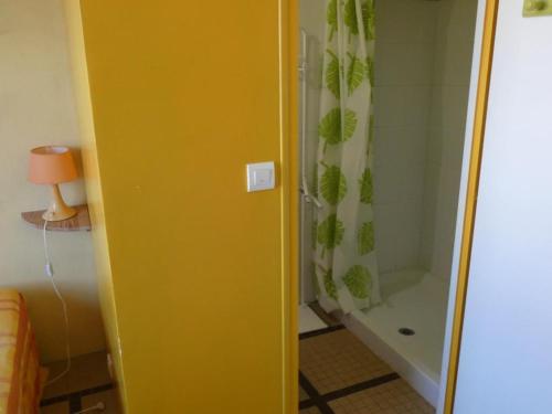 La salle de bains est pourvue d'une porte jaune et d'une douche. dans l'établissement Maison de vacances à 100m de la plage, 4 pers, jardin, stationnement - Notre-Dame-de-Monts - FR-1-540-257, à Notre-Dame-de-Monts
