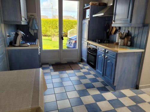 une cuisine avec des placards bleus et un sol en damier dans l'établissement Maison plain-pied proche plage - terrasse plein sud, vélos, jardin, barbecue - 2 chambres, 1 chambre enfants - FR-1-672-32, à Merlimont