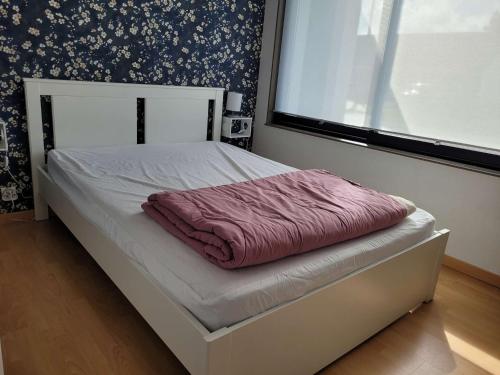 - un lit avec une couverture rose dans une chambre dans l'établissement Maison plain-pied proche plage - terrasse plein sud, vélos, jardin, barbecue - 2 chambres, 1 chambre enfants - FR-1-672-32, à Merlimont