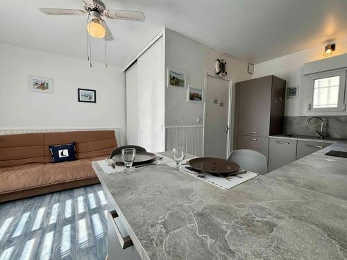 - une cuisine et un salon avec une table et des verres à vin dans l'établissement Studio charmant à La Cotinière proche plages et commerces, terrasse privée, parking inclus - FR-1-246A-291, à Saint-Pierre-dʼOléron