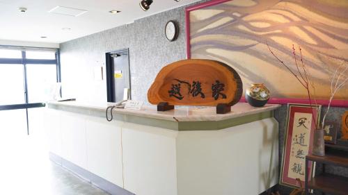 cocina con encimera con reloj en la pared en ビジネス旅館 越後家 en Soka