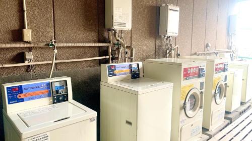 una fila de lavadoras en una lavandería en ビジネス旅館 越後家 en Soka