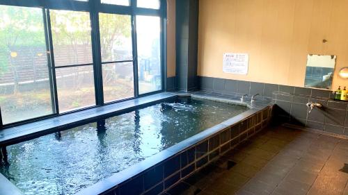 草加市的住宿－ビジネス旅館 越後家，浴室内设有水大浴缸
