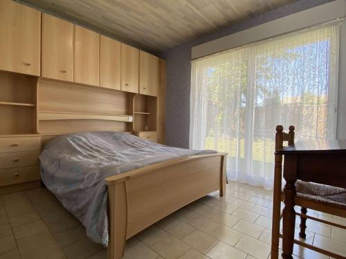 een slaapkamer met een bed en een groot raam bij Maison Saint-Pierre-d'Oléron, 3 pièces, 4 personnes - FR-1-246A-292 in Saint-Pierre-dʼOléron