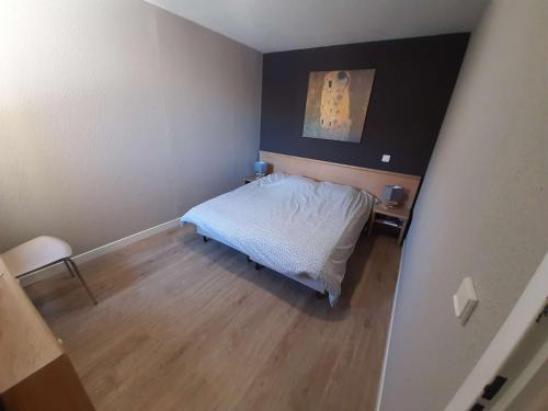 - une petite chambre avec un lit et du parquet dans l'établissement Appartement cosy avec balcon, piscine et sauna - Idéalement situé près des pistes - L'Alpe d'Huez - FR-1-405-358, à Huez