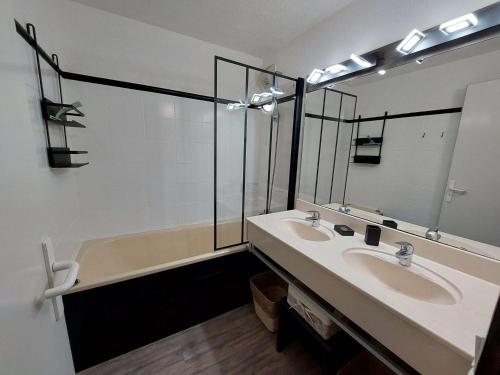 une salle de bain avec deux lavabos et une baignoire dans l'établissement Appartement cosy avec balcon, piscine et sauna - Idéalement situé près des pistes - L'Alpe d'Huez - FR-1-405-358, à Huez