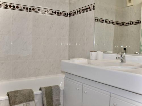 une salle de bain blanche avec un lavabo et une baignoire dans l'établissement Appartement 2 pièces avec parking et climatisation près de la plage - FR-1-252A-117, à Villeneuve-Loubet