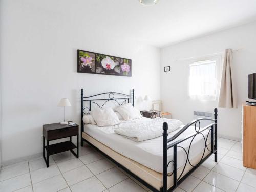 - une chambre dotée d'un lit avec un cadre noir dans l'établissement Villa climatisée avec terrasse, cuisine d’été et WIFI – Proche plage à Narbonne - FR-1-409-261, à Narbonne