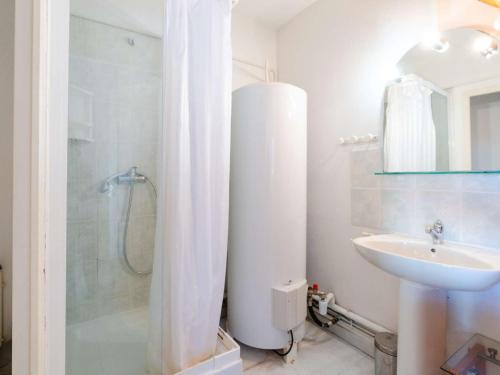 une salle de bain blanche avec une douche et un lavabo dans l'établissement Villa climatisée avec terrasse, cuisine d’été et WIFI – Proche plage à Narbonne - FR-1-409-261, à Narbonne
