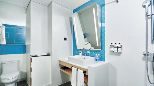a bathroom with a sink and a toilet and a mirror at Holiday Inn Express Beijing Tongzhou Tourism Zone, an IHG Hotel in Beijing