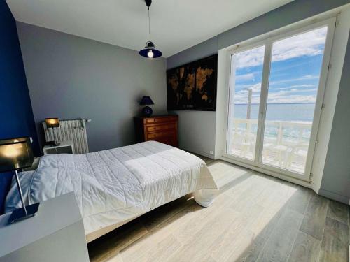 une chambre avec un lit et une grande fenêtre dans l'établissement Quiberon - Appartement 4 pièces 100m² - Front de mer, balcon, parking, WIFI - FR-1-478-274, à Quiberon
