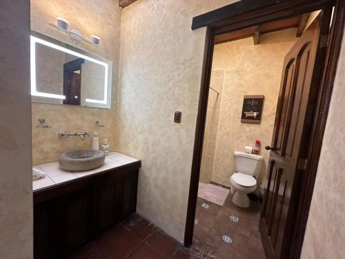 a bathroom with a sink and a toilet at Casa Los Héroes in Antigua Guatemala