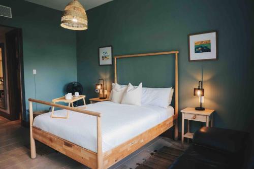 1 dormitorio con cama y pared verde en Modern Condo in Casa de Campo, en La Romana
