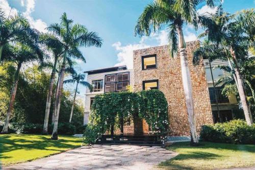 a brick building with palm trees in front of it at Modern Condo in Casa de Campo in La Romana