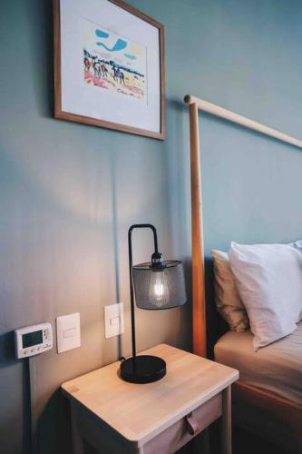 a lamp on a table next to a bed at Modern Condo in Casa de Campo in La Romana
