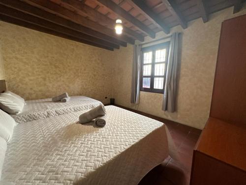 a bedroom with a white bed with a window at Casa Los Héroes in Antigua Guatemala