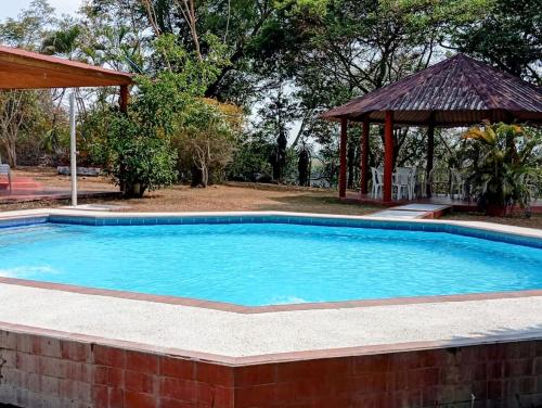 a large swimming pool with a gazebo at Llanitos de Aurora in Ibagué