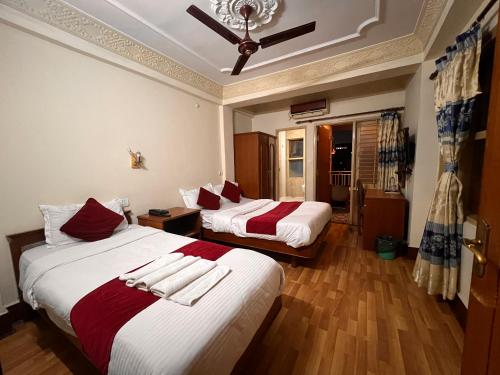 1 dormitorio con 2 camas con sábanas rojas y blancas en Trekkers Home, en Katmandú